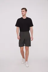 Bermuda de corte recto y diseño minimalista, confeccionada en tejido técnico de poliéster. Presenta cintura elástica con cierre de botón frontal, bolsillos laterales y un bolsillo pequeño adicional en el lateral izquierdo.