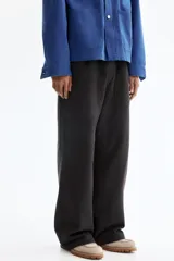 Pantalón jogger de algodón con corte relajado, cintura elástica con cordón ajustable, piernas rectas y bolsillos de parche delanteros.