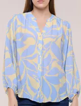 Blusa de gasa texturizada color celeste con estampado abstracto en tono amarillo, de silueta holgada y fluido diseño. Presenta escote en V con cuello a la base y abotonadura frontal con botones a tono. Cuenta con mangas largas abullonadas con puños elastizados.