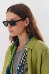 Lentes de sol con marco negro y patillas color carey.