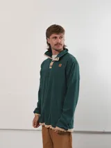 Buzo de pana color beige con cuello polo abotonado y bolsillo en el pecho.