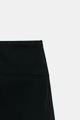 Falda pantalón de tiro bajo con diseño minimalista, falsos bolsillos de vivo en el delantero y cierre lateral con cremallera oculta.