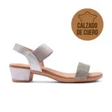 Sandalia de cuero plateada con tiras anchas, una con textura y otra con strass. Tiene taco bloque bajo y pulsera al tobillo con hebilla ajustable.