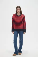 Sweater de tejido de punto con diseño de rayas horizontales en color rojo y azul marino, cuello redondo a la base y mangas largas con corte holgado.