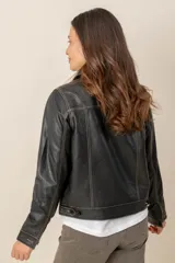 Campera de cuero marrón, con cuello camisero, cierre frontal con botones metálicos y bolsillos frontales.