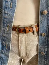 Cinto fino de cuero color marrón con hebilla dorada.