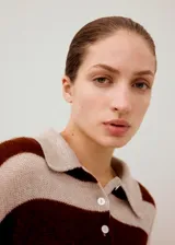 Jersey de punto a rayas horizontales marrones y beige, con cuello polo y cierre frontal de botones.