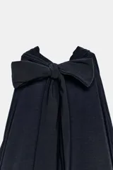 Mono largo negro con cuello halter, hombros descubiertos, parte superior drapeada y piernas anchas con bajo acabado en puño elástico.
