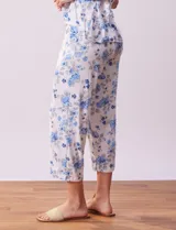 Conjunto de pijama marca René Rofé, compuesto por remera de mangas cortas con escote en V abotonado y pantalón capri con cintura elastizada. Diseño estampado con flores azules sobre fondo blanco.