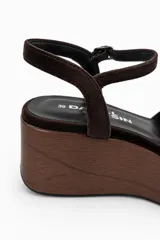 Sandalias de plataforma con efecto madera y terminación gamuzada, con tira en la parte delantera y pulsera ajustable al tobillo con hebilla.