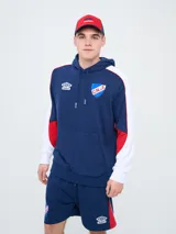 Canguro deportivo Umbro del Club Nacional de Football, modelo Nexo para hombre. Diseño en color azul marino con mangas rojas y detalles en celeste y blanco, capucha con cordón ajustable y bolsillo tipo canguro.