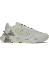 Championes de entrenamiento Under Armour modelo Halo Trainer, color gris con detalles en amarillo neón y estampado animal print en el talón. Presentan amortiguación reactiva UA HOVR, parte superior ligera con perforaciones para ventilación y suela de goma con ranuras de flexión para mayor tracción.