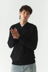 Campera negra tejida con textura en el frontal, escote redondo y puños.