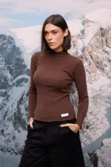 Polera de tejido de punto fino color marrón, con cuello alto, mangas largas y terminaciones con detalle de ondas (ruloté) en cuello, puños y ruedo.