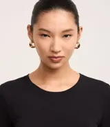 Blusa de algodón color negro, de corte ajustado, con cuello redondo y mangas largas.