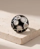 Anillo de acero de diseño redondo, con esmalte negro y detalles en nácar.