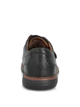 Zapato de cuero negro con cierre de velcro, suela de goma EVA flexible y diseño ergonómico.