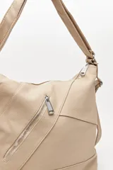 Cartera convertible en mochila, confeccionada en cuero sintético texturizado color marrón. Presenta un diseño con recortes, bolsillo frontal con cierre diagonal, herrajes metálicos plateados, asa superior y correas regulables.