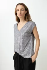 Top sin mangas color plateado con escote en V, completamente cubierto de lentejuelas.
