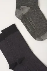 Pack de dos pares de medias de caña media con diseño de espiga. Un par en tono gris y otro en tono negro, ambos con puntera y talón reforzados y detalle de marca en el empeine.
