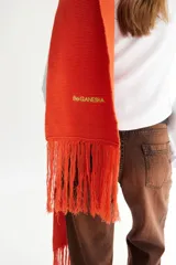 Bufanda de algodón color marrón con flecos en los extremos y logo bordado en amarillo.