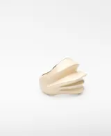 Anillo de metal con relieve y acabado lacado en color beige, de diseño voluminoso e irregular con interior dorado y logo grabado.