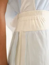 Pollera larga de lino color celeste con diseño superpuesto en capas de tonos claros.