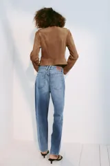 Jeans mom fit de tiro alto confeccionados en denim azul claro, con diseño de cinco bolsillos, trabillas para cinturón y cierre frontal con cremallera y botón metálico.