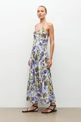Maxi vestido largo de tirantes con cuello en V, corte fluido y estampado floral en tonos azules y verdes sobre base blanca.