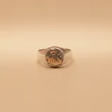 Anillo tipo sello de plata 925 con aplique central en oro 9k que representa el símbolo de la partera. Diseño clásico con acabado pulido.