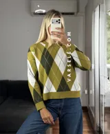 Sweater de tejido de punto con diseño de rombos en tonos verde oliva, verde oscuro y blanco. Presenta cuello redondo, mangas largas con puños acanalados y un corte holgado.