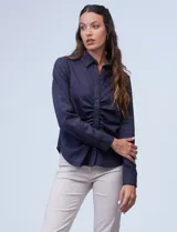 Camisa azul en símil suede, marca Ninety. Cuello con solapa y abertura central con botones. Delantera fruncida.