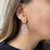 Aros colgantes con base circular rosa, detalle de strass y dije transparente con diseño abstracto celeste.