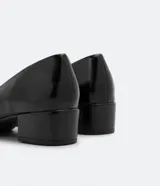 Zapato femenino tipo scarpin de color marrón, con puntera fina y tacón bloque de altura media.