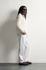 Sweater de punto verde con diseño de trenzas, cuello redondo y manga larga, de corte regular fit y acabados en rib.