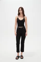 Musculosa de bretel fino color negro, confeccionada en tejido acanalado con detalles de encaje en el escote en V y tirantes delgados.