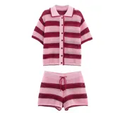 Conjunto de dos piezas tejido a crochet con diseño de rayas horizontales en tonos rosa y rojo. Incluye una camisa de manga corta con cuello polo y cierre frontal de botones, y un short con cintura elástica y cordón ajustable.