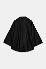 Camisa de corte holgado confeccionada en mezcla de lino, con estampado de rayas verticales en color marrón y blanco. Presenta cuello solapa, escote en pico, cierre frontal con botones y mangas amplias por debajo del codo con puños definidos.