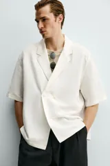 Camisa tipo kimono de corte relaxed fit, color celeste, confeccionada en tejido fluido de viscosa y lino. Presenta cuello con solapas de muesca, manga corta y cierre frontal cruzado con doble botonadura.