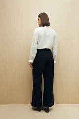 Pantalón wide leg color crudo, de tiro alto, con grandes bolsillos laterales y traseros.