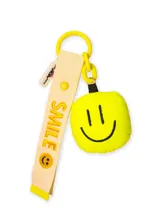 Llavero de cinta color crema con la palabra 'SMILE' bordada en amarillo y un dije acolchado en forma de carita feliz color amarillo neón. Incluye una argolla y eslabones de plástico amarillo.