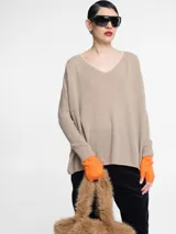 Sweater de tejido de punto color beige con escote en V y mangas largas.