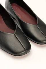 Chatas planas de cuero color plateado metálico, con punta cuadrada y un pequeño tacón bajo de madera.