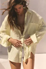 Camisa de corte oversize confeccionada en tejido de gasa color amarillo claro. Presenta cuello solapa, cierre frontal con botones, manga larga con hombro caído y puños definidos, además de un bolsillo de plastrón en el frente y detalle de pinza en la espalda.