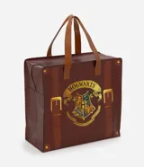 Bolsa de compras marrón con diseño de maleta y estampa frontal del escudo de Hogwarts. Cuenta con asas dobles de mano y cierre superior.