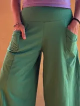 Pantalón tipo palazzo de tiro alto, confeccionado en jersey de algodón color verde. Presenta un diseño amplio con bolsillos laterales y una faja ancha en la cintura que proporciona soporte y ajuste.