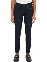 Pantalón de jean azul oscuro, corte skinny, tiro alto y largo hasta el tobillo.