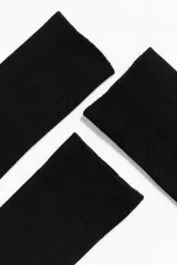 Pack de tres pares de medias de vestir negras, de caña media, confeccionadas en tejido de punto de algodón con textura acanalada y puño elástico.