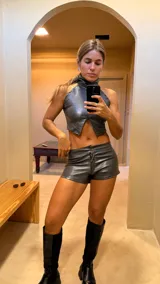 Top gris brillante con cuello alto y corte irregular en el bajo.