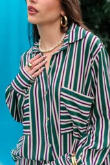Camisa de fibrana con diseño de rayas verticales rojas y blancas, corte oversize, mangas largas abullonadas, cuello camisero y bolsillos frontales con solapa.